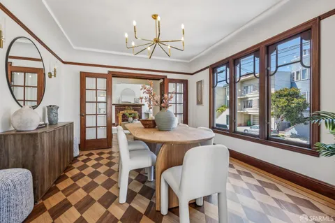 a view of a dining room with furniture a chandelier and wooden floor
