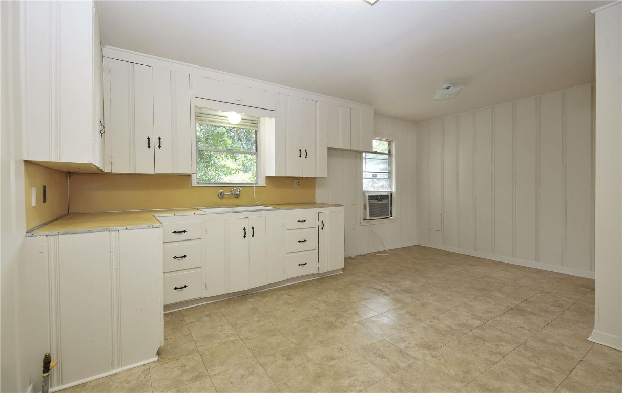 108 West Mink Street Willis, TX 77378 - Photo 6 of 12 a kitchen with granite countertop white cabinets and sink