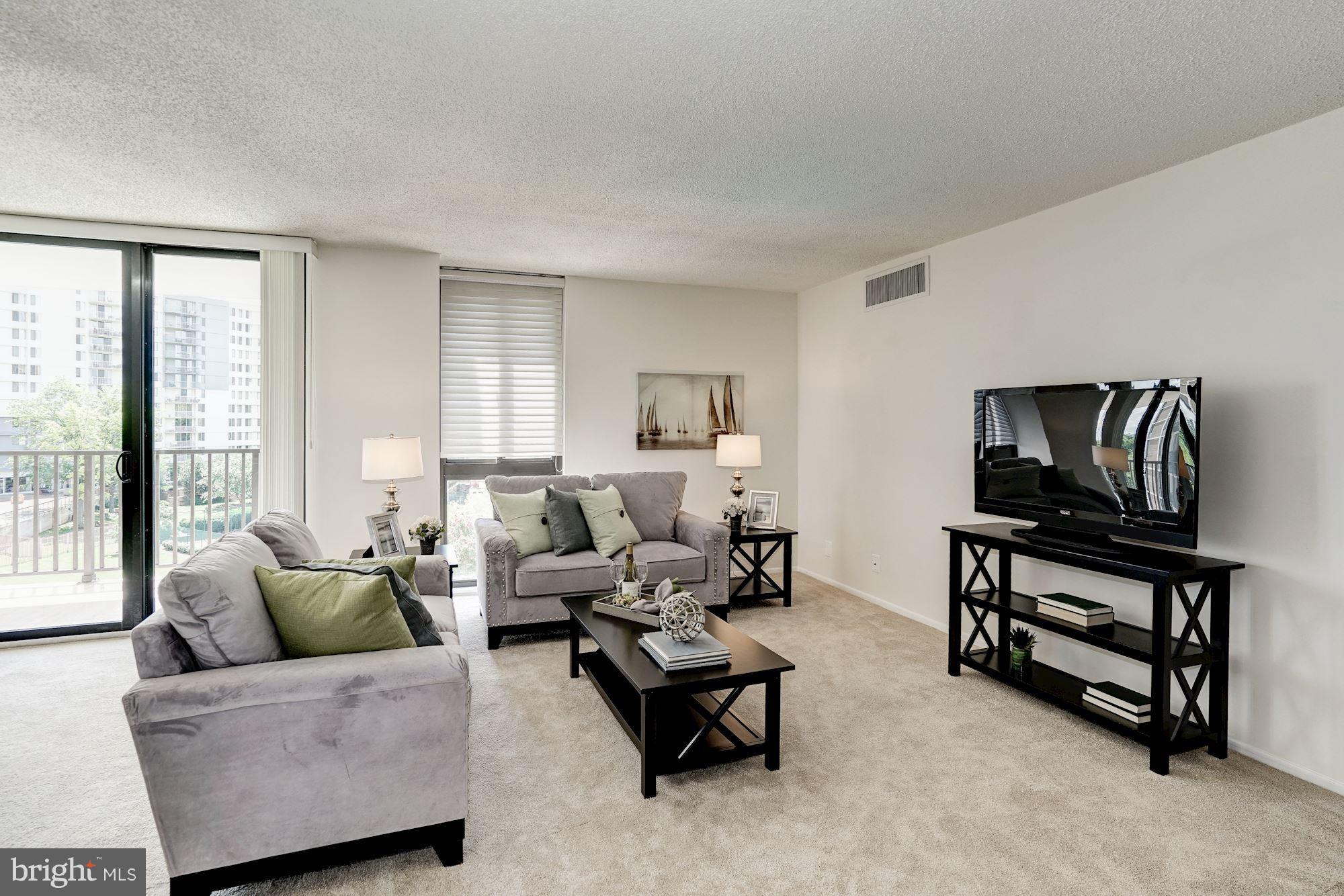 6800 Fleetwood Road, Unit 610 McLean, VA 22101 - Photo 1 of 26 a living room with furniture and a flat screen tv