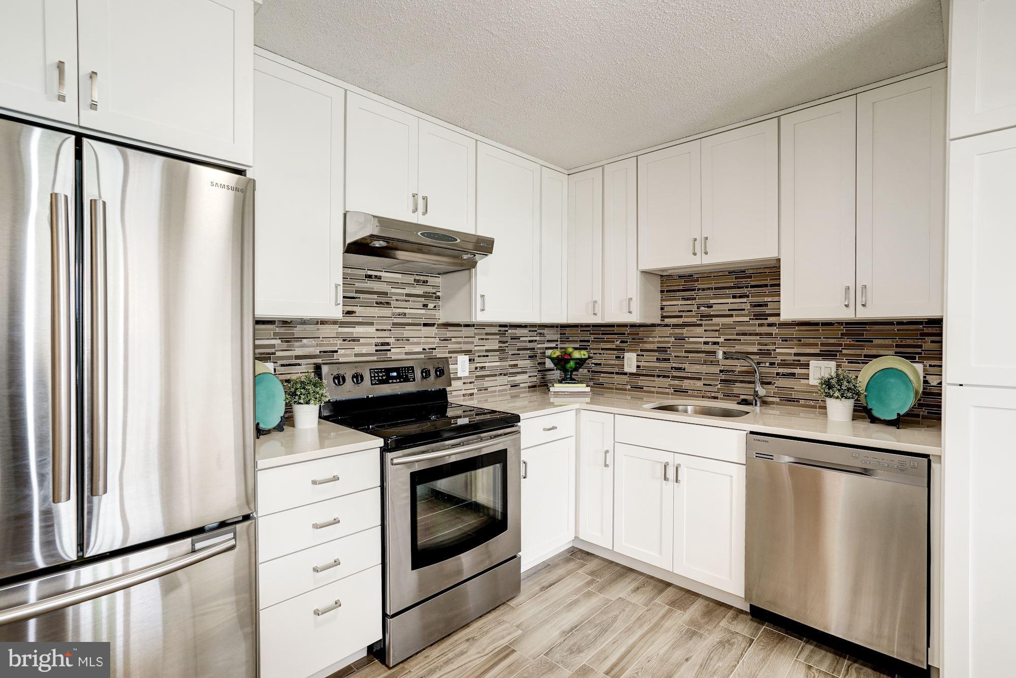 6800 Fleetwood Road, Unit 610 McLean, VA 22101 - Photo 4 of 26 a kitchen with white cabinets and white appliances