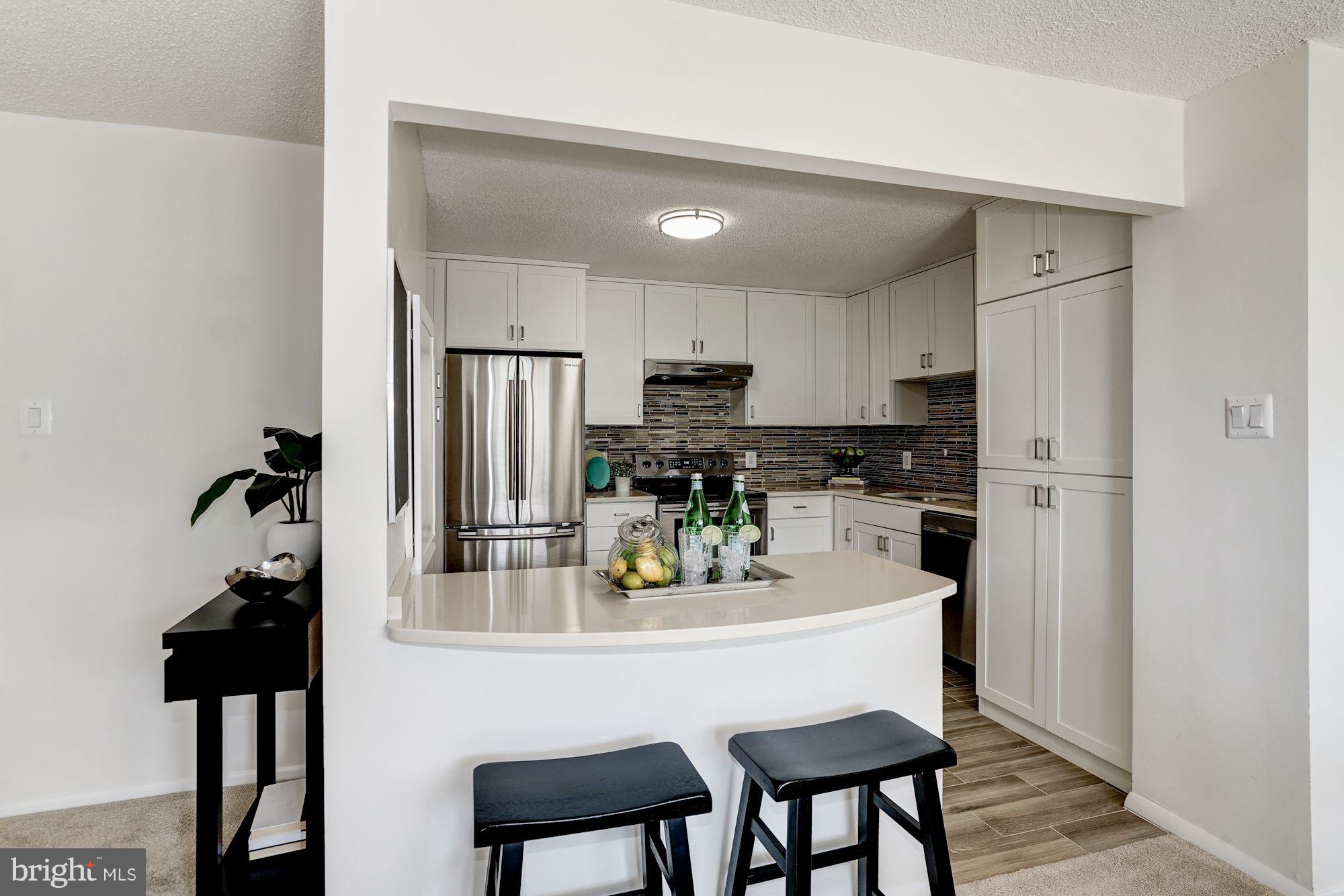 6800 Fleetwood Road, Unit 610 McLean, VA 22101 - Photo 7 of 26 a kitchen with a refrigerator and stools