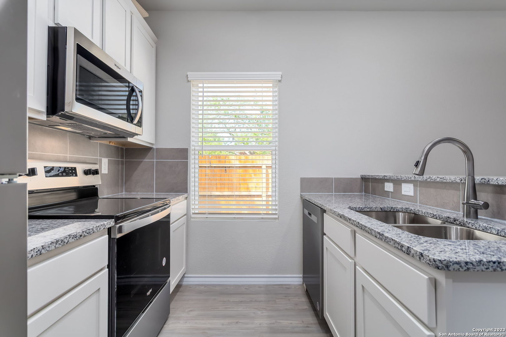 402 Trefger Street Seguin, TX 78155 - Photo 8 of 10 a kitchen with granite countertop a sink stainless steel appliances and cabinets