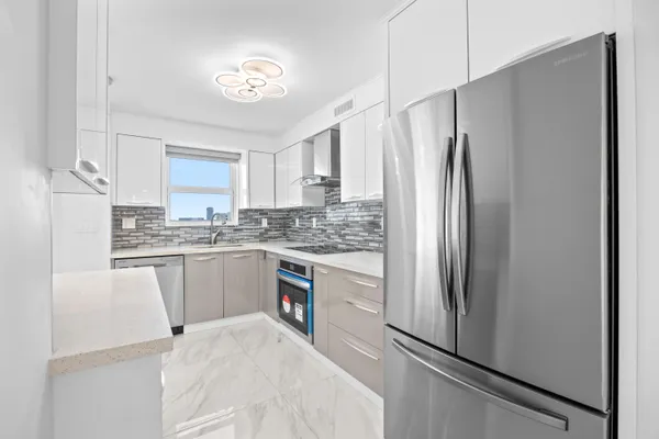 a kitchen with a refrigerator a sink and cabinets