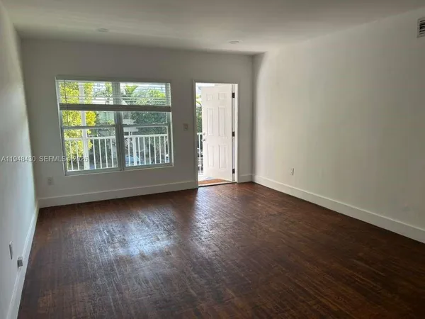a view of a room with wooden floor and window