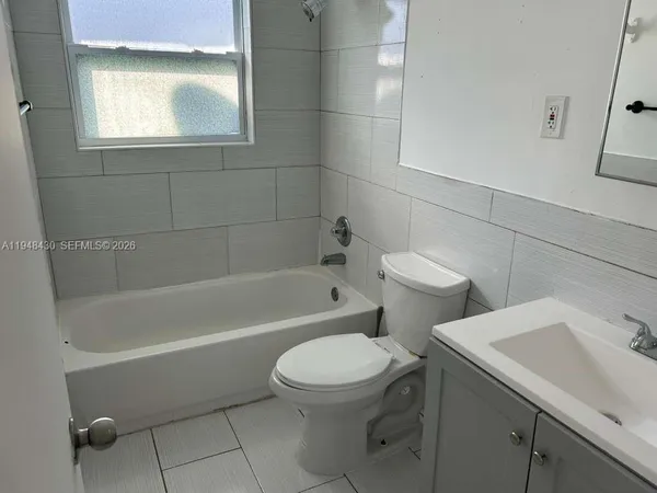 a white toilet sitting next to a bath tub