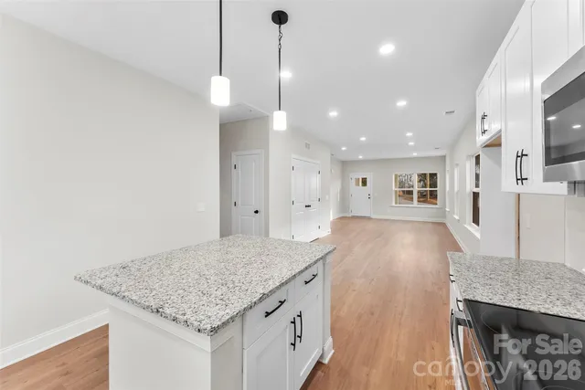 a kitchen with kitchen island a counter top space a sink stainless steel appliances and cabinets