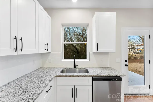 a kitchen with granite countertop a sink and a stove