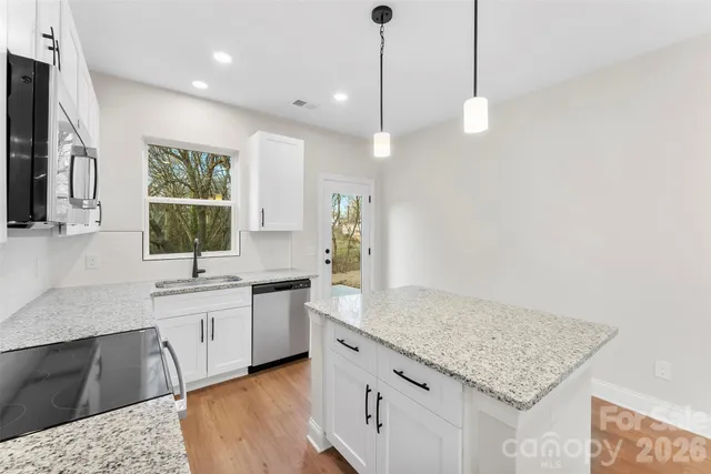 a kitchen with a sink center island and stainless steel appliances