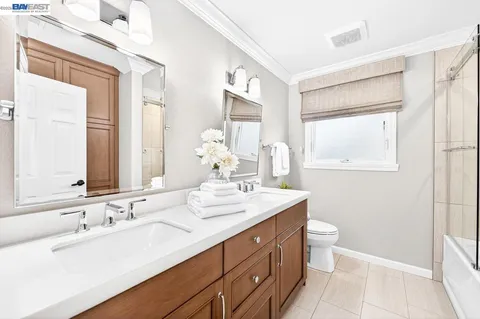 a bathroom with a double vanity sink a toilet and a mirror