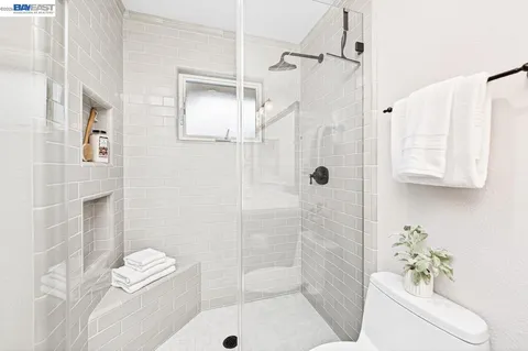 a spacious bathroom with a granite countertop double vanity sink a mirror and a shower