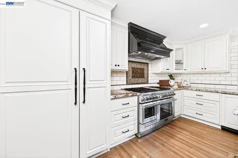 a kitchen with stainless steel appliances white cabinets and a stove