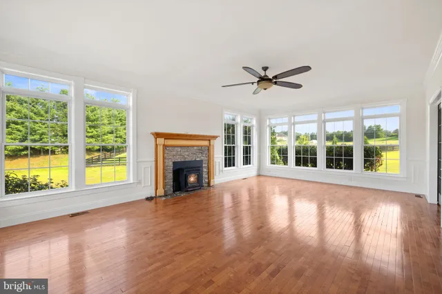 a large white kitchen with a sink and a stove top oven with wooden floor