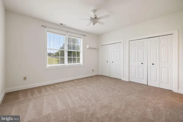 a bathroom with a granite countertop sink toilet and mirror