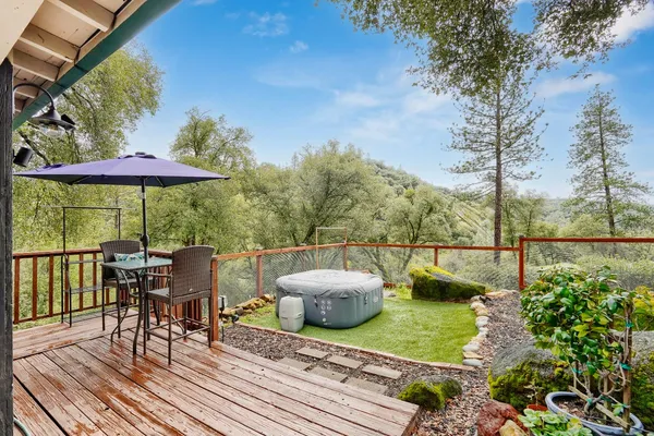 a view of a patio with couches table and chairs under an umbrella with a barbeque