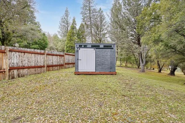 a view of backyard with wooden fence
