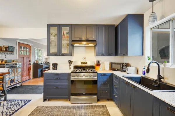 a kitchen with stainless steel appliances granite countertop a stove sink and cabinets
