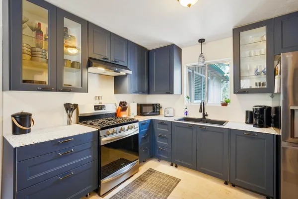 a kitchen with stainless steel appliances granite countertop a sink stove and cabinets