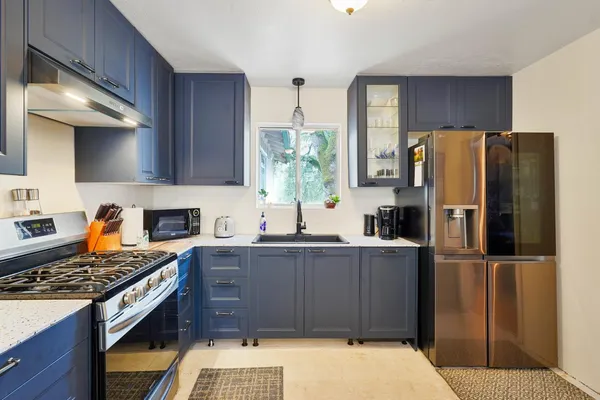 a kitchen with stainless steel appliances granite countertop a refrigerator and a stove top oven