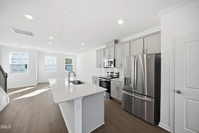 a kitchen with a sink a counter top space stainless steel appliances and cabinets