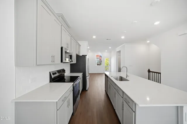 a kitchen with stainless steel appliances a refrigerator sink and microwave