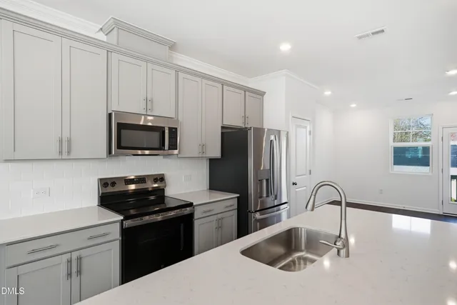 a kitchen with stainless steel appliances a stove a microwave and cabinets