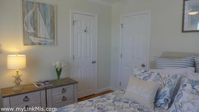 a bedroom with a bed and a potted plant on the dresser