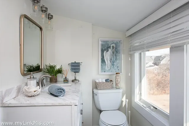 a bathroom with a granite countertop sink toilet and mirror