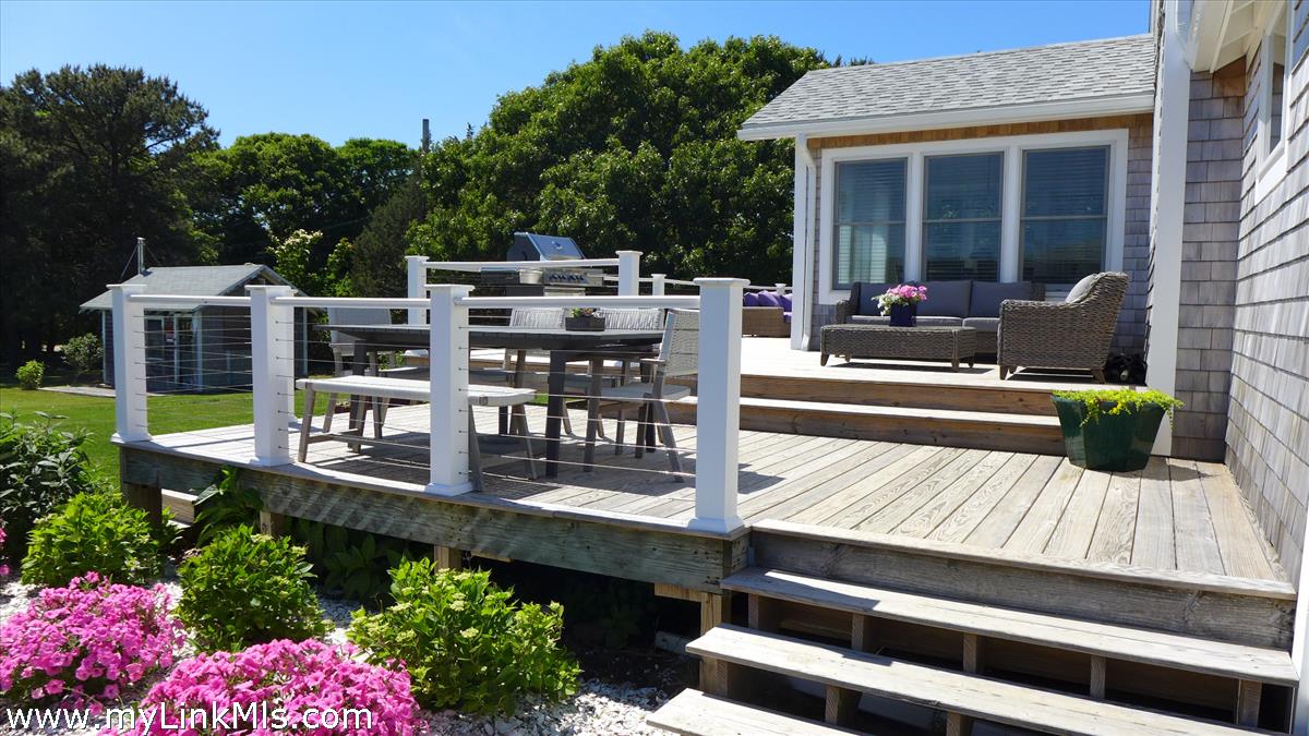 34 Windemere Road Oak Bluffs, MA 02557 - Photo 31 of 44 a view of a deck with table and chairs and potted plants