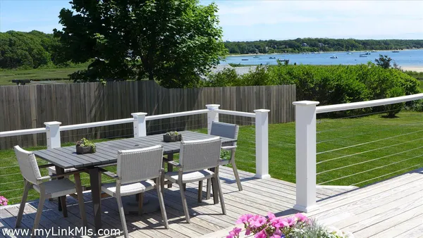 a view of a patio with a table chairs and a small yard