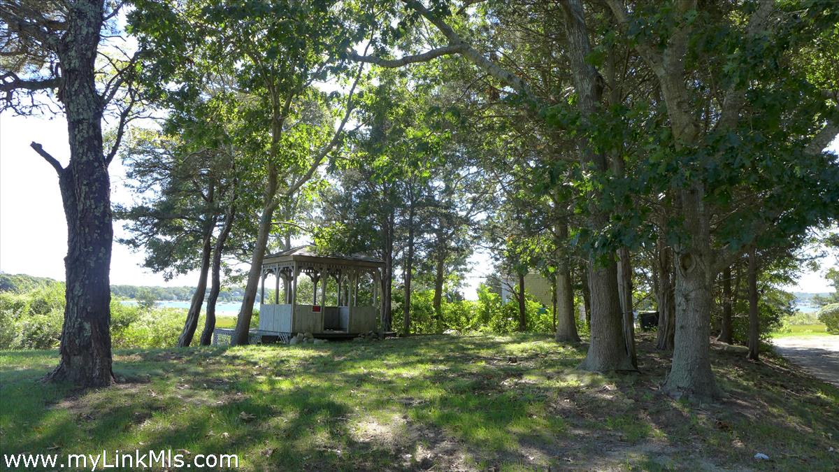 34 Windemere Road Oak Bluffs, MA 02557 - Photo 42 of 44 a backyard of a house with trees and outdoor seating