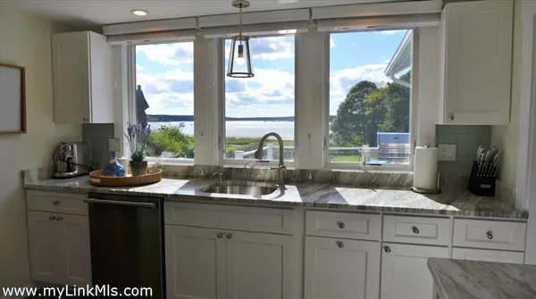 a kitchen with a sink a window and cabinets