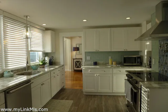 a kitchen with a sink a window stainless steel appliances and cabinets