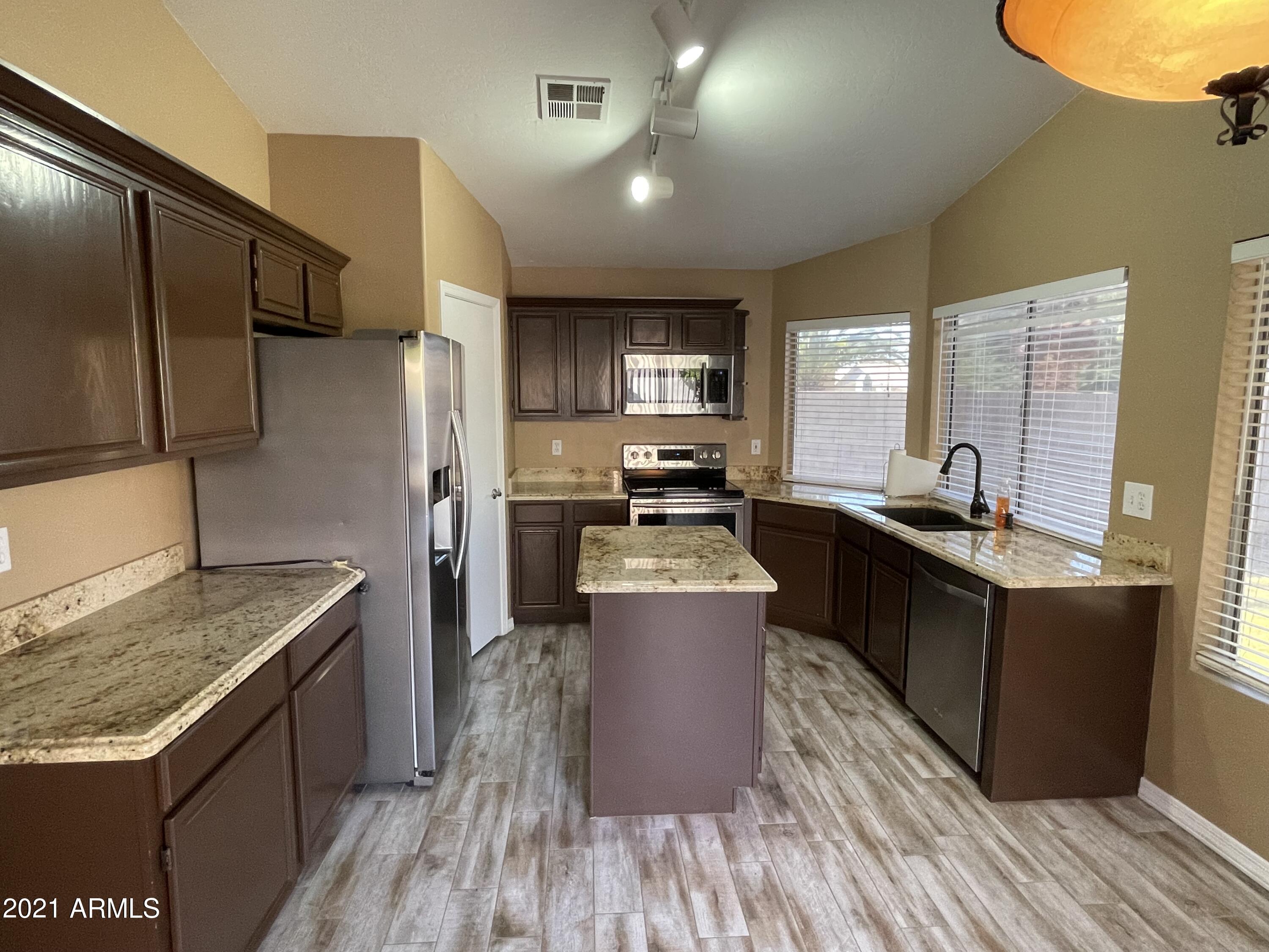 2702 South Ananea Mesa, AZ 85209 - Photo 2 of 15 a kitchen with stainless steel appliances granite countertop a sink stove and refrigerator