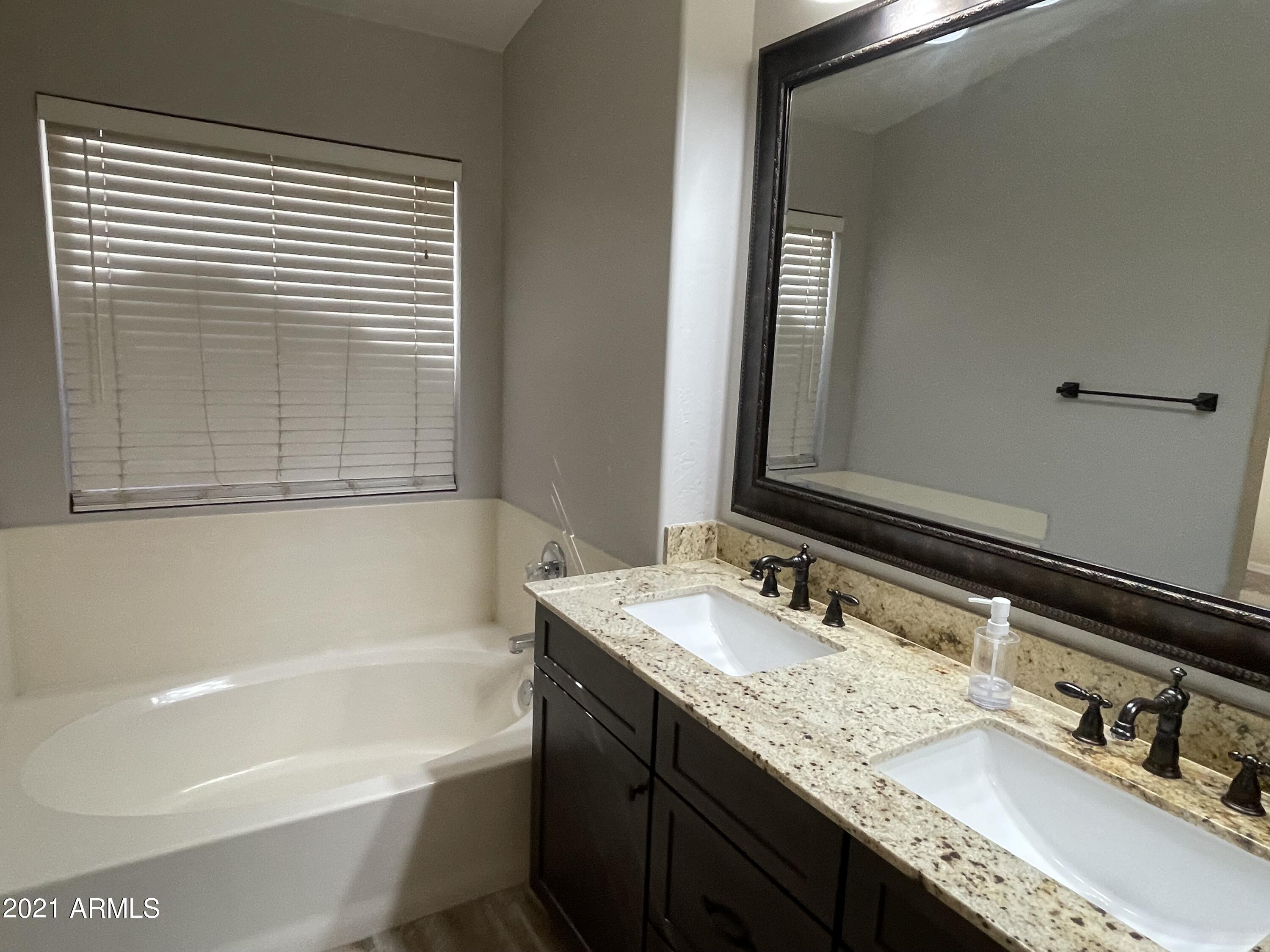 2702 South Ananea Mesa, AZ 85209 - Photo 7 of 15 a bathroom with a granite countertop tub sink and mirror