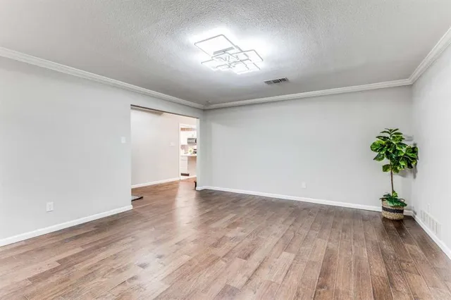 a view of a room with wooden floor and a potted plant