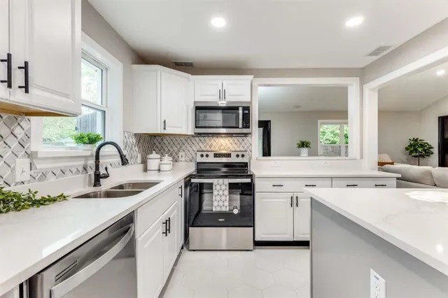 a kitchen with stainless steel appliances granite countertop a sink and cabinets