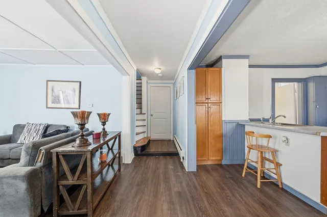 a view of a kitchen with furniture and wooden floor