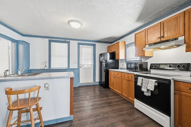 a kitchen with stainless steel appliances granite countertop a kitchen island hardwood floor sink stove and granite counter top