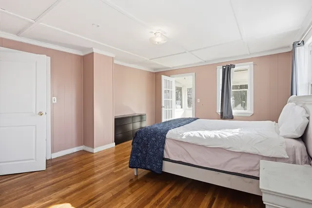 a bedroom with a large bed wooden floor and window