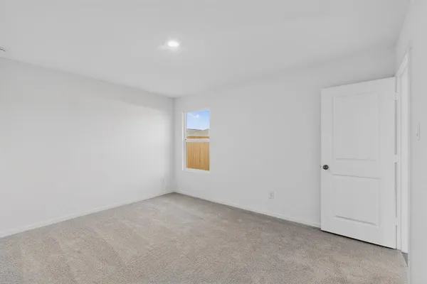 an empty room with a window and a mirror