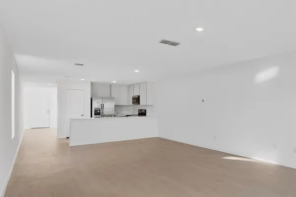 a kitchen with a sink a refrigerator a microwave and cabinets