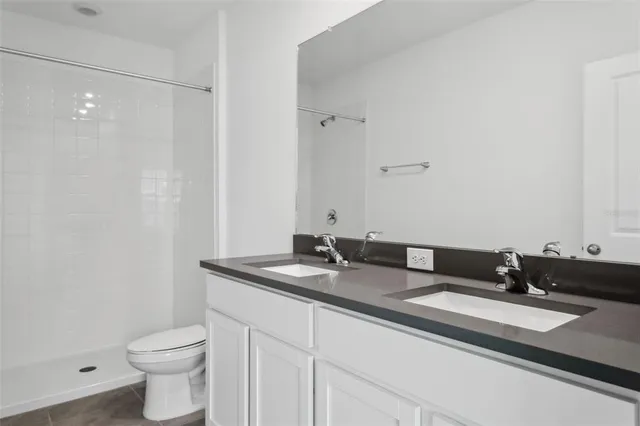 a bathroom with a granite countertop sink a toilet and a mirror