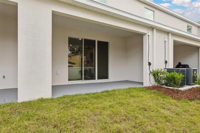 a view of a white house with a swimming pool table and chairs
