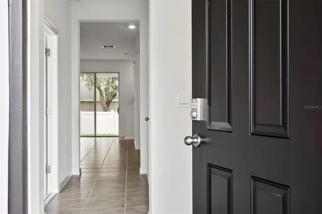 a view of a hallway with wooden floor and windows