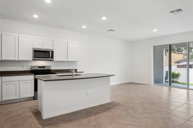 a kitchen with stainless steel appliances a stove a sink and a microwave