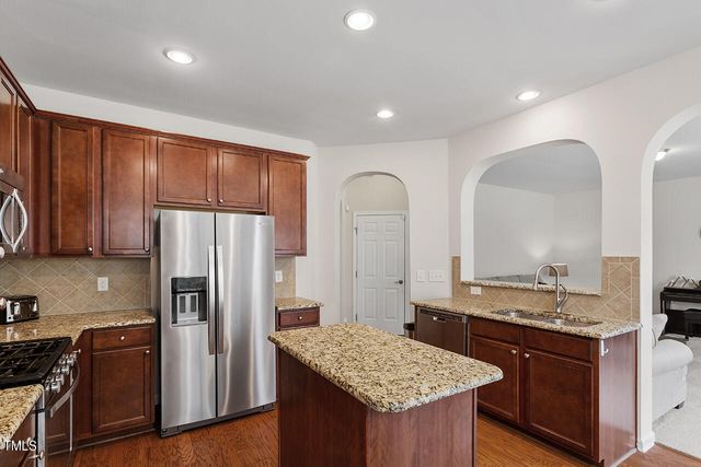 a kitchen with stainless steel appliances granite countertop a refrigerator and a sink