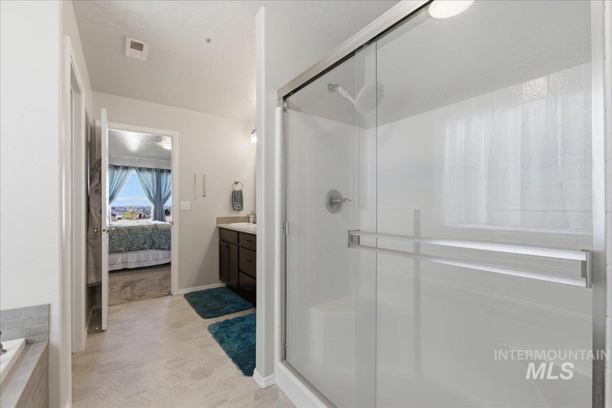 16202 Dietz Way Caldwell, ID 83607 - Photo 16 of 31 Ensuite bathroom with vanity, a shower stall, and a bath