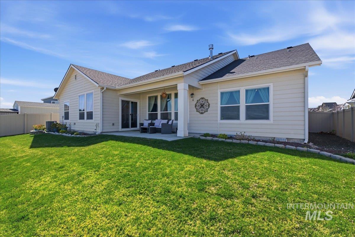 16202 Dietz Way Caldwell, ID 83607 - Photo 25 of 31 Back of house featuring a fenced backyard, a patio, an outdoor hangout area, and roof with shingles
