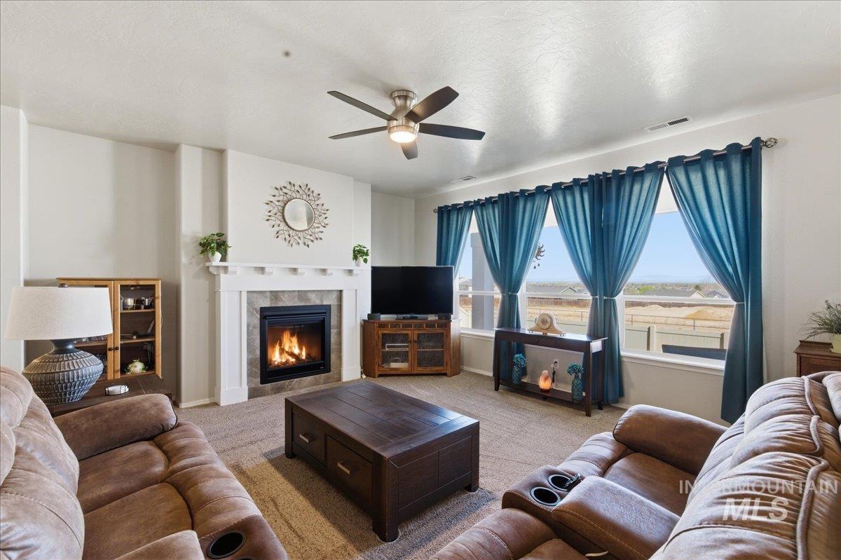16202 Dietz Way Caldwell, ID 83607 - Photo 4 of 31 Carpeted living area with a ceiling fan, a fireplace, and a textured ceiling