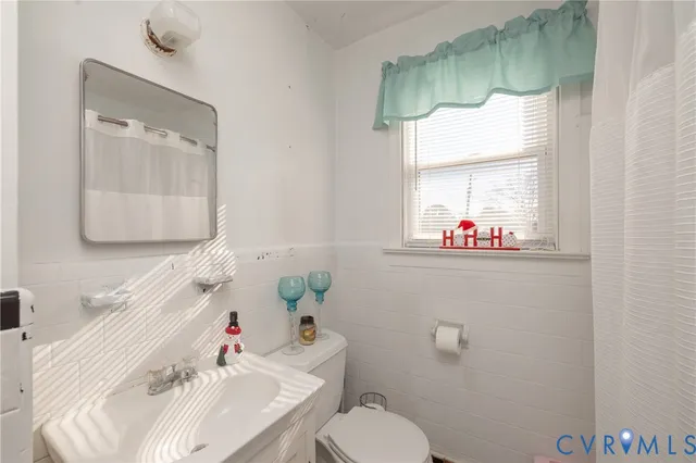 a bathroom with a sink mirror and toilet
